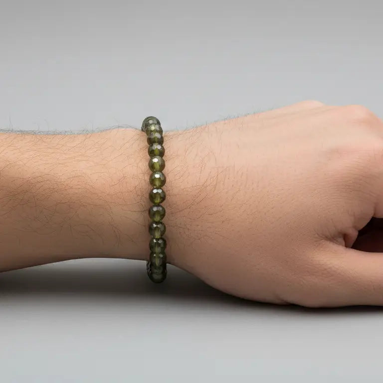 Peridot Faceted Bracelet on a wrist and light grey background