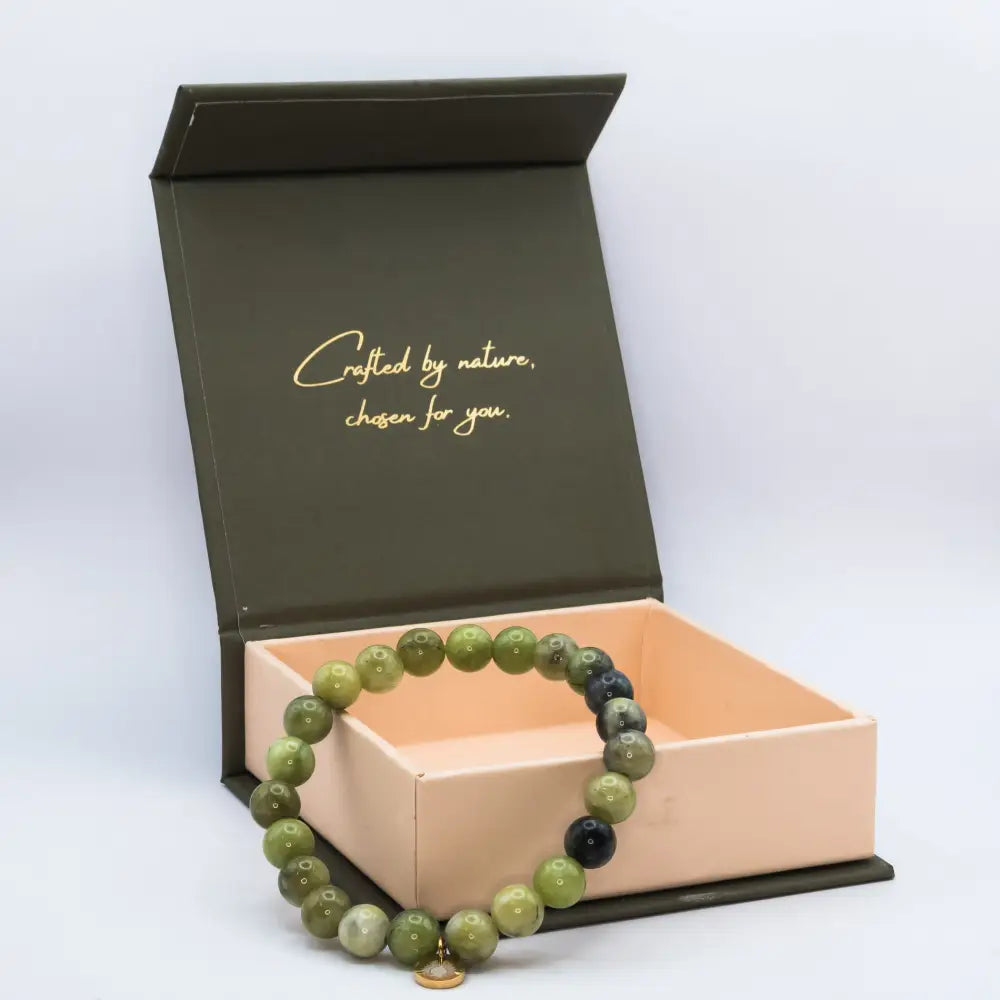 Peridot Beaded Bracelet with gold charm on a cream and olive green branded box with light grey background