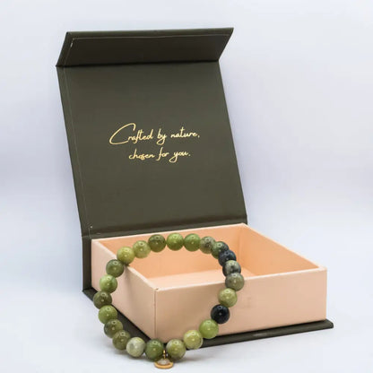 Peridot Beaded Bracelet with gold charm on a cream and olive green branded box with light grey background