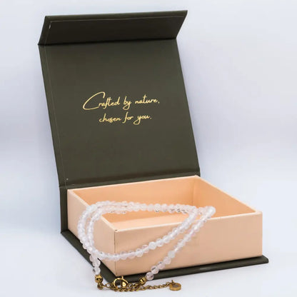 Rose Quartz Faceted Necklace on a cream and olive green branded box, neutral background
