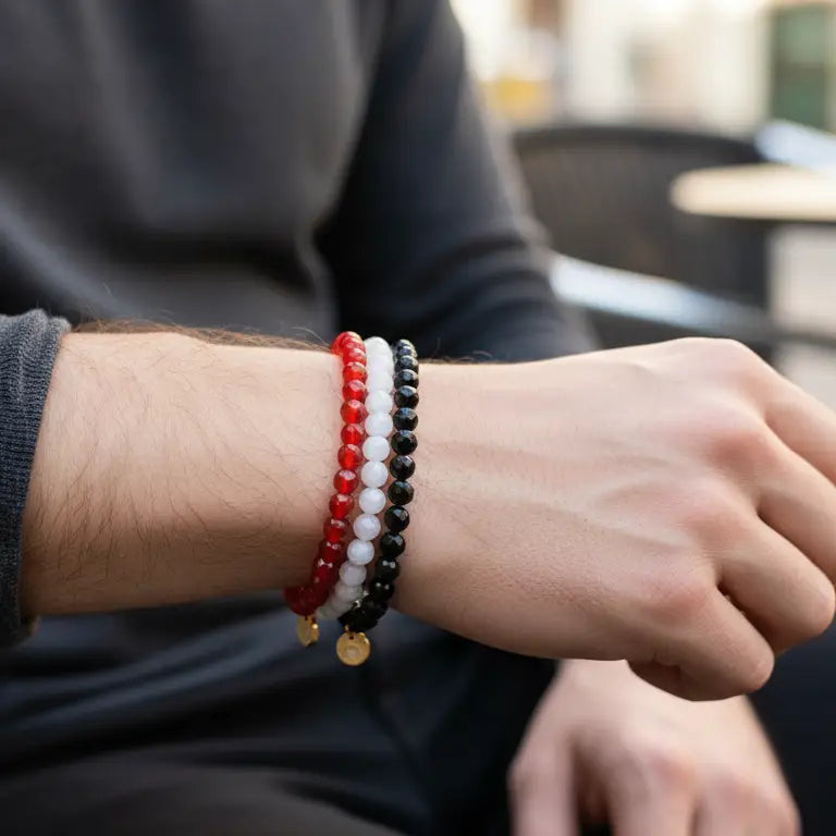 Person wearing Carnelian, Moonstone, and Black Tourmaline faceted beaded bracelets with gold charms on an outdoor setting